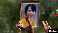 Seseorang memegang foto pemimpin Aung San Suu Kyi saat warga Myanmar memprotes kudeta militer, 22 Februari 2021. (Foto: REUTERS/Soe Zeya Tun)