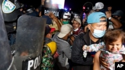 Bezbednosne snage Hondurasa pokušavaju da zadrže migrante koji pokušavaju da se domognu SAD, na graničnom prelazu Hondurasa ka Gvatamali, El Florido, 15. januara 2021. (AP Photo/Delmer Martinez)