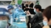 Des gens reçoivent des vaccins contre le coronavirus Covid-19 dans un centre de vaccination temporaire à Pékin le 8 janvier 2021. (Photo de STR / CNS / AFP) / China OUT