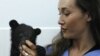 Actress Maggie Q, a goodwill ambassador for Moon Bear Rescue Vietnam, plays with an Asiatic black bear cub at the Vietnam Bear Rescue Centre in Tam Dao National Park, north of Hanoi May 14, 2009. 