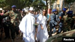 Le président gambien Yahya Jammeh, entouré de garde militaire, arrive à un bureau de vote avec son épouse Zineb lors de l'élection présidentielle à Banjul, Gambie, 1er décembre 2016