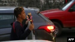 Un venezolano que vive en Ecuador vende piruletas mientras pide ayuda en una esquina del norte de Quito.