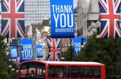 A bus is seen passing underneath Union Jack flags and banners with a message reading "Thank you #ourheroes" in Oxford Street, following the outbreak of the coronavirus disease (COVID-19), London, Britain, June 11, 2020.