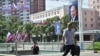 Місцеві мешканці Північної Кореї проходять повз портрета президента Росії Путіна біля прапорів Північної Кореї та Росії в Пхеньяні 20 червня 2024 року, виставлених з нагоди візиту Путіна. Фото: Kim Won Jin/AFP