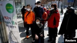 南韓新冠病毒確診病例不斷攀升，重災區大邱市民眾閱讀有關郵局販賣口罩的說明(2020年3月5日)