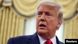 U.S. President Donald Trump responds to a question from a reporter after a medal ceremony in the Oval Office at the White House in Washington, U.S. December 3, 2020. 