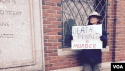 Sud binosi oldidagi namoyishchi. Plakatdagi yozuv: "O'lim jazosi - qotillik". Boston, 5-mart 2015-yil