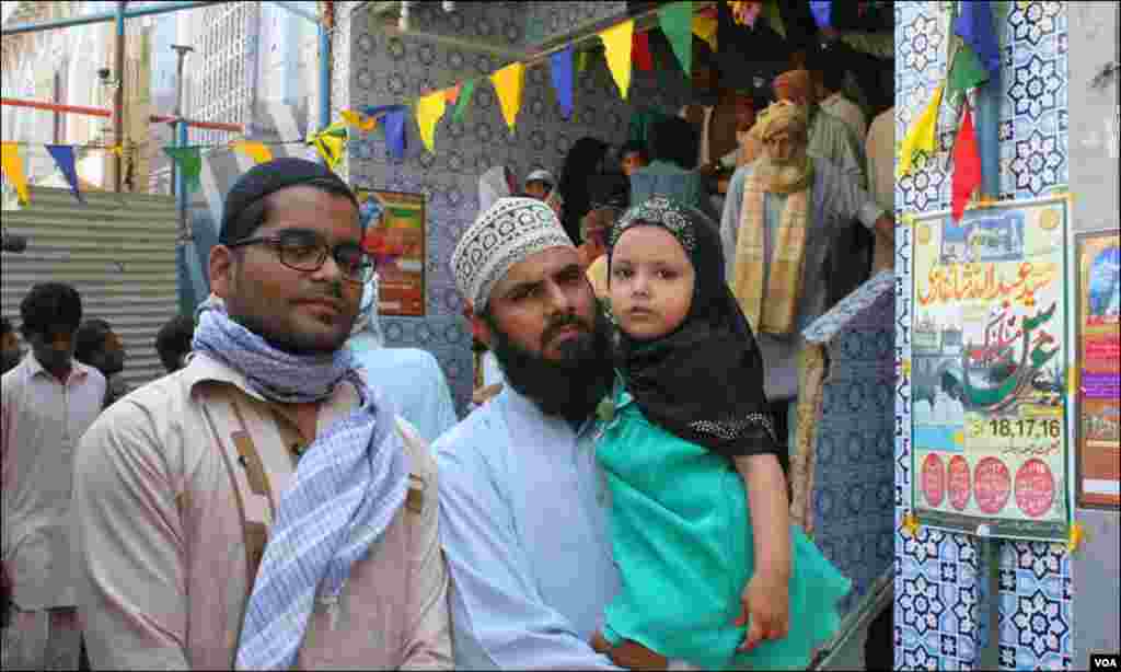 مزار پر آنے والے لاکھوں حاضرین میں شامل ایک بچی اپنے والد کی گود میں
