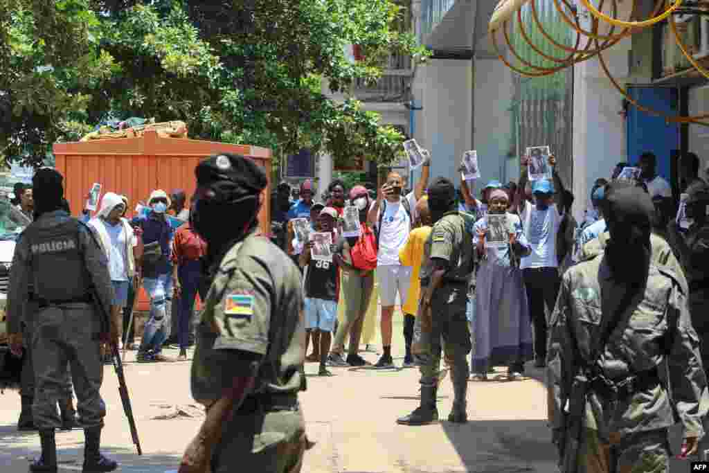 Polícia da República de Moçambique e manifestantes com cartazes do líder da oposição moçambicana Venâncio Mondlane em Maputo, a 15 de Janeiro de 2025, enquanto Daniel Chapo toma posse como Presidente de Moçambique no dia 15 de janeiro de 2025.