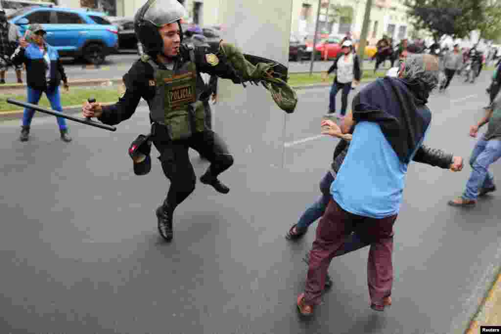 Un policía se enfrenta a los manifestantes durante una protesta que exige elecciones presidenciales y el cierre del Congreso luego de que el derrocado líder peruano Pedro Castillo fuera detenido en una prisión policial luego de su destitución, en Lima, Perú, el 8 de diciembre de 2022. REUTERS/Sebastian Castaneda