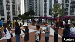 香港選民星期天（11月24日）排隊在區議會選舉中投票。