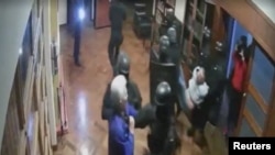 Captura de pantalla de una grabación de circuito cerrado de televisión donde se ve a las fuerzas de seguridad de Ecuador irrumpiendo en la embajada de México en Ecuador y enfrentándose a un funcionario mexicano, en Quito, Ecuador, el 5 de abril de 2024.