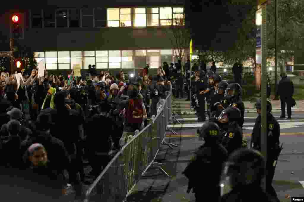 Protesters chant in front of a police line outside Berkley Police Department headquarters during a march against the New York City grand jury decision to not indict in the death of Eric Garner in Berkeley, CA, Dec. 9, 2014.