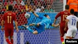 Penjaga gawang Spanyol Iker Casillas berusaha menyelamatkan bola tendangan pemain Chile Charles Aranguiz, Rabu (18/6).