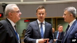 Mađarski šef diplomatije Peter Sijarto (C) razgovara sa kolegom sa Malte Karmelom Abelom (D) i evropskim komesarom za međunarodnu saradnju Nevenom Mimicom tokom sastanka ministara EU, 28. maj 2018.