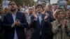 Para pemimpin Catalonia, dari kiri: Wakil Presiden Oriol Junqueras, Presiden Carles Puigdemont, Ketua parlemen regional Catalan Carme Forcadell, bertepuk tangan dalam aksi protes di Barcelona, Sabtu (21/10). 