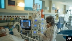 Un trabajador médico trata a un paciente con COVID-19 en la unidad de cuidados intensivos del hospital Oceanico, en Niteroi, Brasil, el viernes 11 de diciembre de 2020.