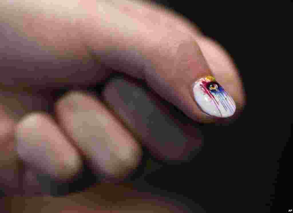 Yihang Shen shows off his nail after demonstrating the Inail Intelligent Printer at CES Unveiled, a media preview event for CES International, Jan. 4, 2016, in Las Vegas. The device prints directly on finger and toenails as well as fake nails.
