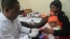 FILE - A doctor tests a child for malaria at a hospital in Arusha, Tanzania, May 11, 2016. 