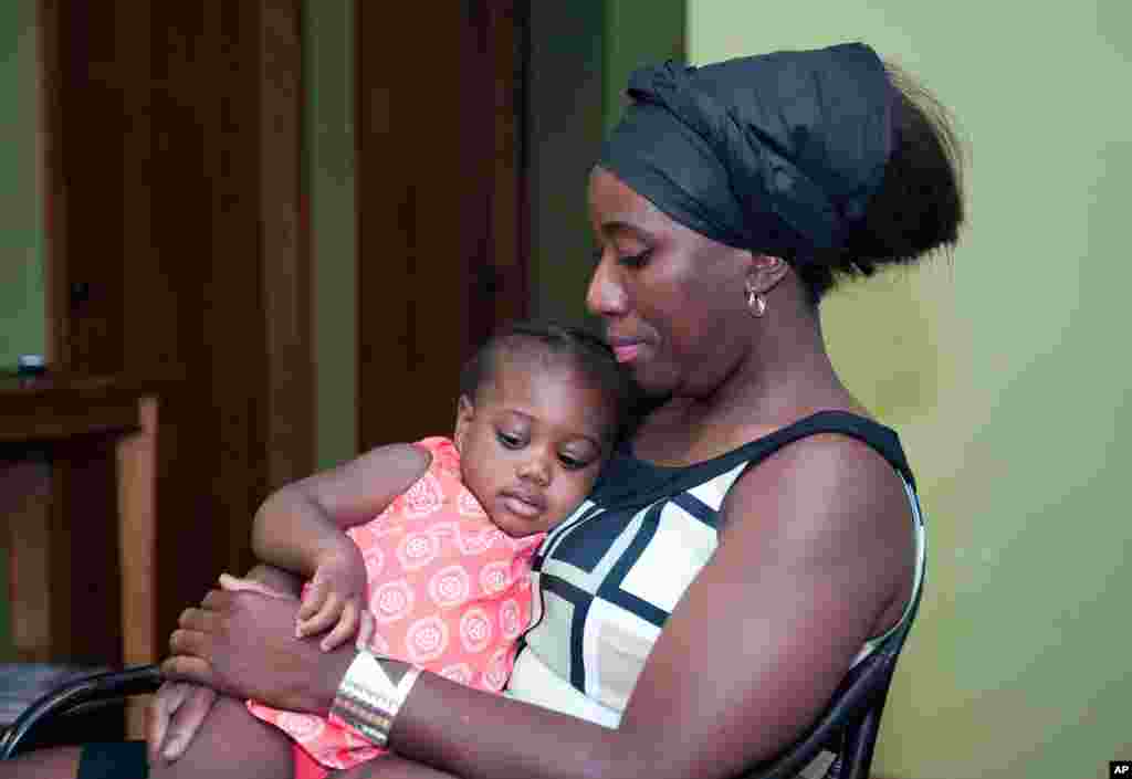 Decontee Sawyer, wife of Liberian government official Patrick Sawyer, a U.S. citizen who died from Ebola after traveling from Liberia to Nigeria, cradles her 1-year-old daughter, Bella, at her home in Coon Rapids, Minnesota, July 29, 2014. 