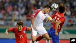 2일 인천 아시안게임 남자 축구 결승전 경기에서 한국의 이정호(오른쪽) 선수와 북한의 장성혁 선수가 공중에 뜬 공을 잡아내기 위해 뛰어올랐다.