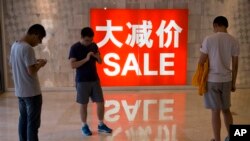 资料照片；中国购物者站在购物区的促销广告附近。