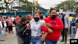 Familiares de reclusos lloran mientras esperan noticias sobre sus seres queridos luego de que 58 reclusos murieran en un motín en la cárcel Guayas 1 en Guayaquil, Ecuador, el 13 de noviembre de 2021.