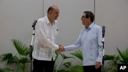 El canciller cubano Bruno Rodríguez, a la derecha, recibe a su contraparte de Colombia, Álvaro Leyva, en La Habana, Cuba, el jueves 11 de agosto de 2022. (AP Foto/Ismael Francisco)
