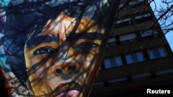 Una pancarta con un retrato del futbolista argentino Diego Maradona cuelga afuera del hospital donde fue ingresado por anemia y deshidratación, según su médico personal. Buenos Aires, Argentina, 3 de noviembre de 2020.