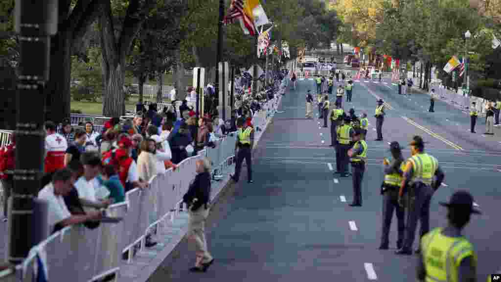 Une foule et des agents de sécurité postés le long de l'itinéraire papale attendent sur la 17e rue en face de Constitution Avenue, Washington, 23 septembre 2015.