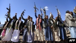 Pria-pria Yaman bersenjata mengangkat senjata mereka saat berkumpul dekat ibukota Sanaa untuk menunjukkan dukungan mereka kepada pemberontak Syiah Houthi terhadap koalisi pimpinan Arab Saudi. 21 Februari 2019 (foto: Mohammed Huwais/AFP)