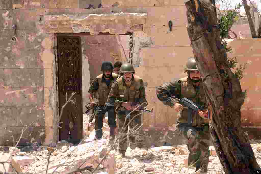 Forces loyal to Syrian President Bashar Assad during clashes against Syrian rebels in Aleppo, May 26, 2013.
