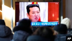 2022年1月1日，韩国首尔地铁站人们在观看电视中朝鲜领导人金正恩的画面。 