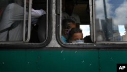 Un niño con tapabocas mira por la ventana de un autobús en Caracas, Venezuela. Sábado 6 de junio de 2020.