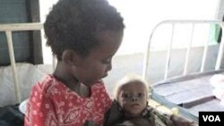 Abdi Nur Ibrahim, 1, que está siendo tratado por desnutrición severa, es cuidado por su hermana mayor en un hospital de Médicos Sin Fronteras.