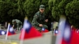 一名台灣軍人在金門古寧頭戰役75週年紀念儀式上為公共墓地的一座墳墓上香。 (2024年10月25日)