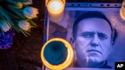 Фотографія російського опозиціонера Олексія Навального з квітами та свічками перед посольством Росії у Вільнюсі, Литва, п'ятниця, 16 лютого 2024 року. Фото AP