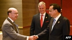 美国商务部长罗斯(左)在泰国首都曼谷出席东盟会议期间与中国总理李克强(右)握手（2019年11月4日）。