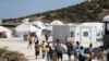 Refugees and migrants from the destroyed Moria camp enter a new temporary camp on the island of Lesbos, Greece, Sept. 20, 2020. 
