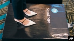 En esta imagen, proporcionada por Air New Zealand, una mujer se para en una báscula para pesarse antes de tomar un vuelo en Auckland, Nueva Zelanda, el 29 de mayo de 2023.