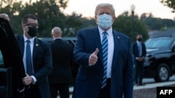US President Donald Trump gives the thumbs-up as he leaves Walter Reed Medical Center
