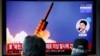People watch a TV showing a file picture for a news report on North Korea firing two unidentified projectiles, in Seoul, South Korea, March 2, 2020.