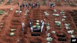 Groblje Vila Formosa u Sao Paolu u Brazilu. Radnici sa zaštitnom opremom sahranjuju osobe preminule od Kovida-19. 