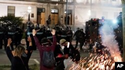Policías intentan repeler a manifestantes que intentaron acercarse a la Corte de Kenosha, en el segundo día de protestas.