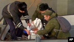 In this Tuesday, Dec. 27, 2016 frame grab made available by Russian Rossiya One TV Channel Emergency Ministry soldiers pack a flight recorder of the crashed plane, on a pier just outside Sochi, Russia.