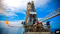 Discoverer Enterprise on the site of the Deepwater Horizon incident. Gas from the damaged wellhead is burned by the drillship, in a process known as flaring.