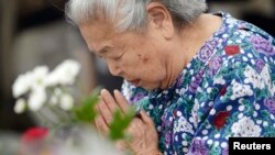 Seorang perempuan Jepang mengenang korban bom atom dengan berdoa di Taman Perdamaian di Hiroshima, Rabu (6/8). 