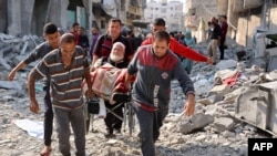 Wasu Falasdinawa dauke da wani tsohon mutun a kan kujera bayan tankokin Isra’ila sun kutsa da kai hari a Jabalia arewacin Gaza - Nuwamba 10, 2024.