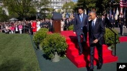 President Barack Obama walks with Japanese Prime Minister Shinzo Abe during a ceremony on the White House South Lawn in Washington, April 28, 2015.