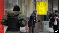 Чоловік просить милостиню біля пункту обміну валют у Києві, 13 листопада 2014 р. 